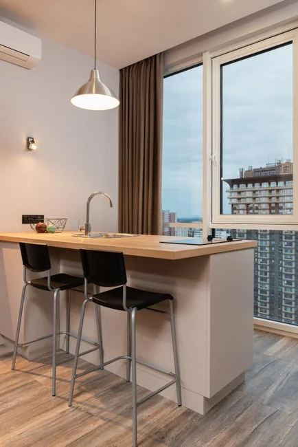 A woman in a gray sweater wipes a table with care, showcasing home cleaning in comfort.